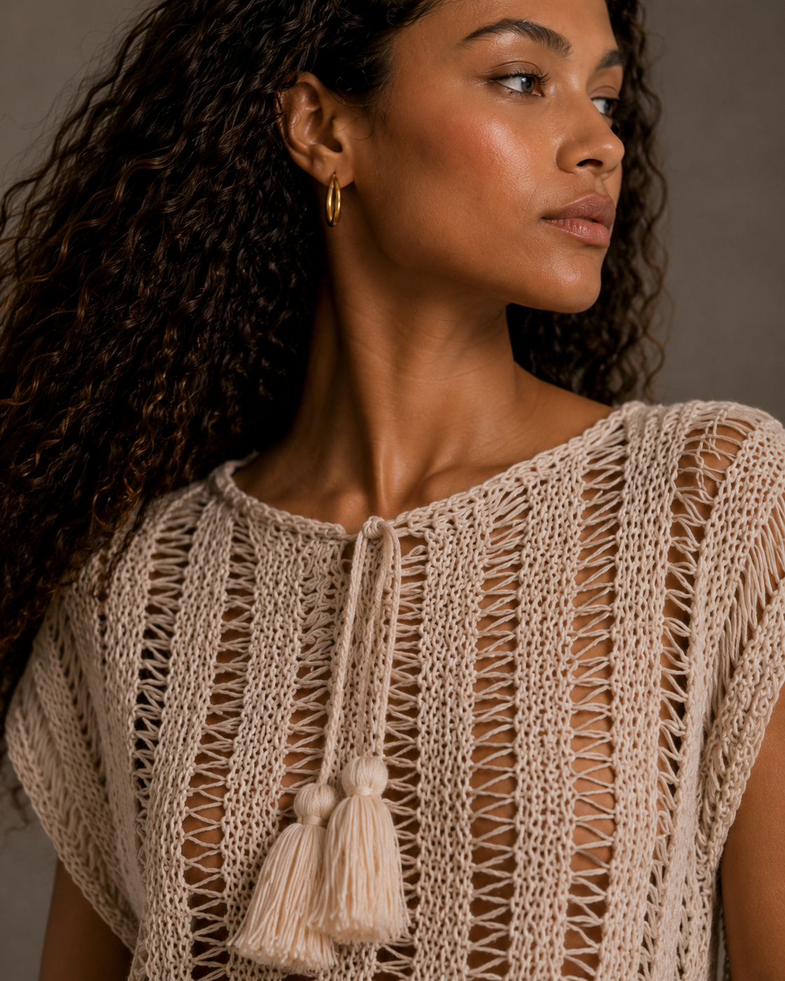 Cream top with tassels and adjustable drawstring collar. s-m-l